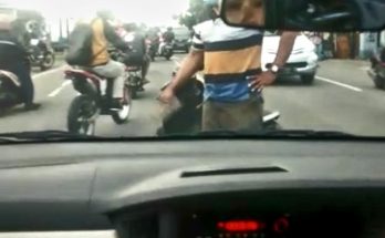 Seorang lelaki membawa paving menghentikan pengendara mobil di Jalan Raya Sukomulyo, Kecamatan Manyar, Gresik pada Jumat, 19 Februari 2021 (foto : screenshot video)