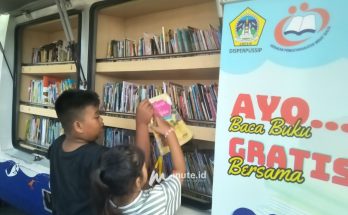 Dua anak sedang memilih buku bacaan di mobil perpustakaan milik Dinas Perpustakaan dan Kearsipan Gresik di arena car free day Jalan Jaksa Agung Suprapto, Gresik (Foto : Chusnul Cahyadi/1minute.id)